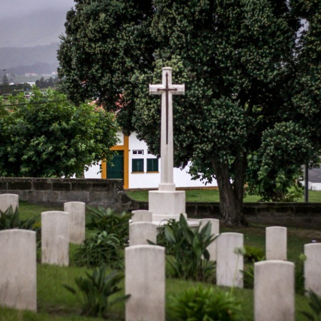 Rows of white gravestones and a stone cross at the war cemetery in Lajes on the island of Terceira.